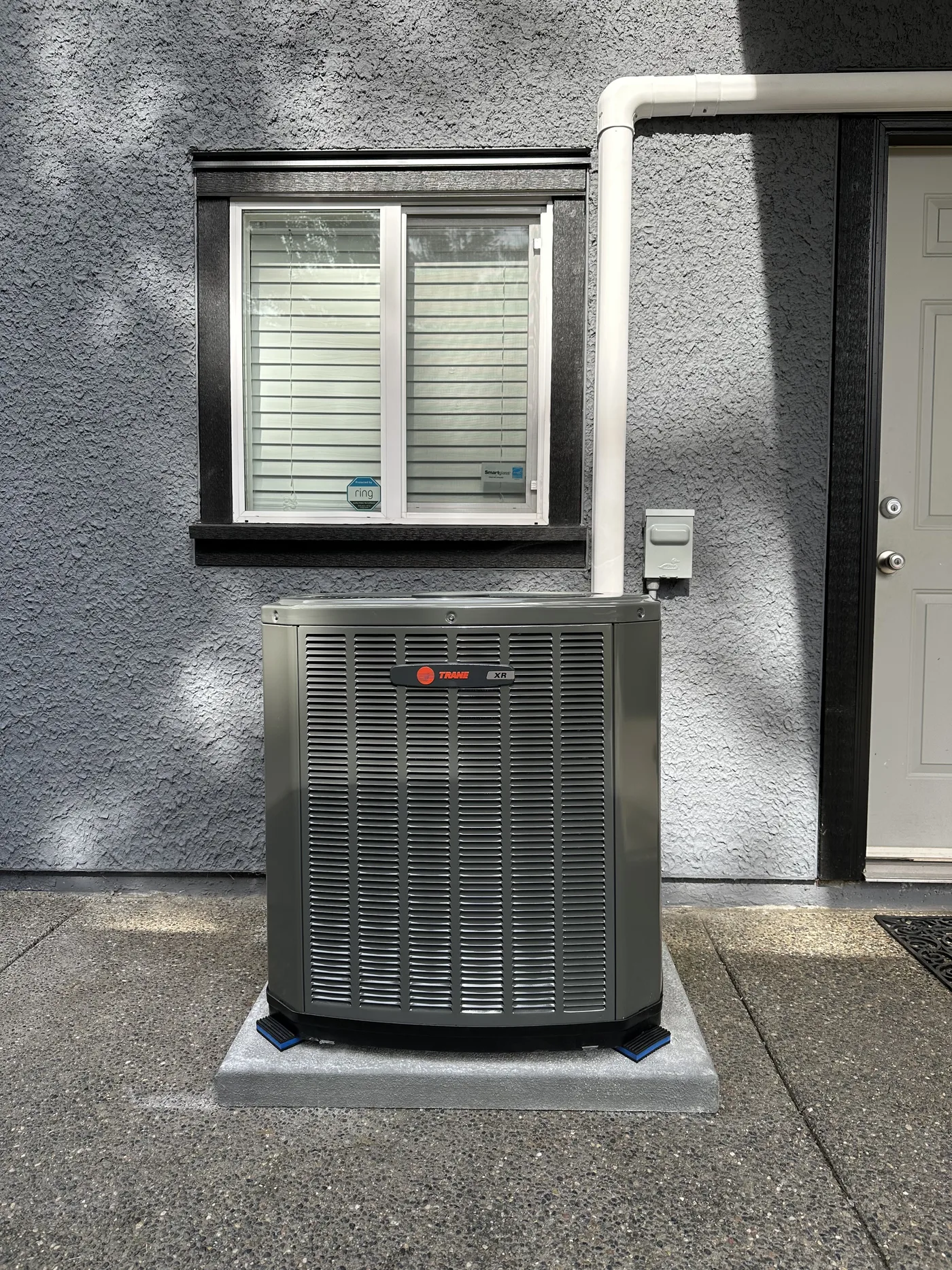 Compact unit tucked tight to the house, out of the way